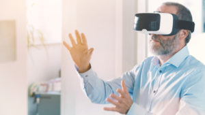 Mature business man wearing virtual reality googles / VR Glasses to work with in modern office